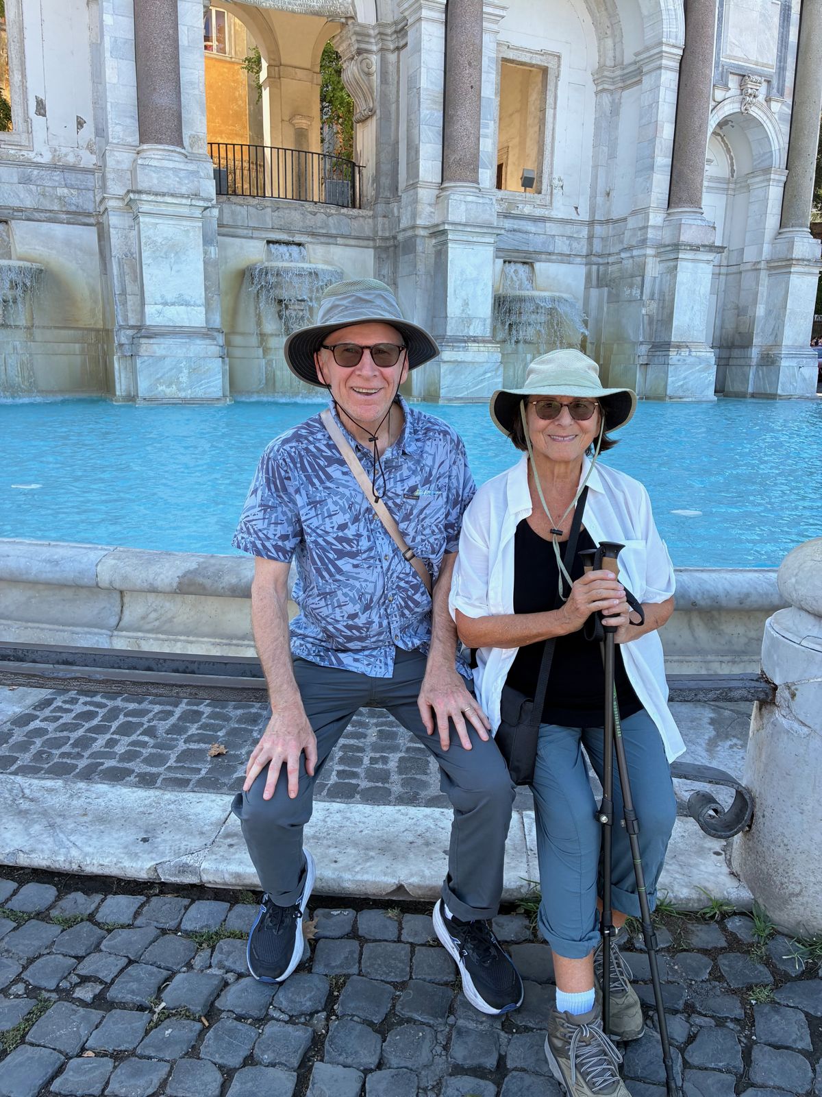 Two travelers resting beside a fountain in Rome