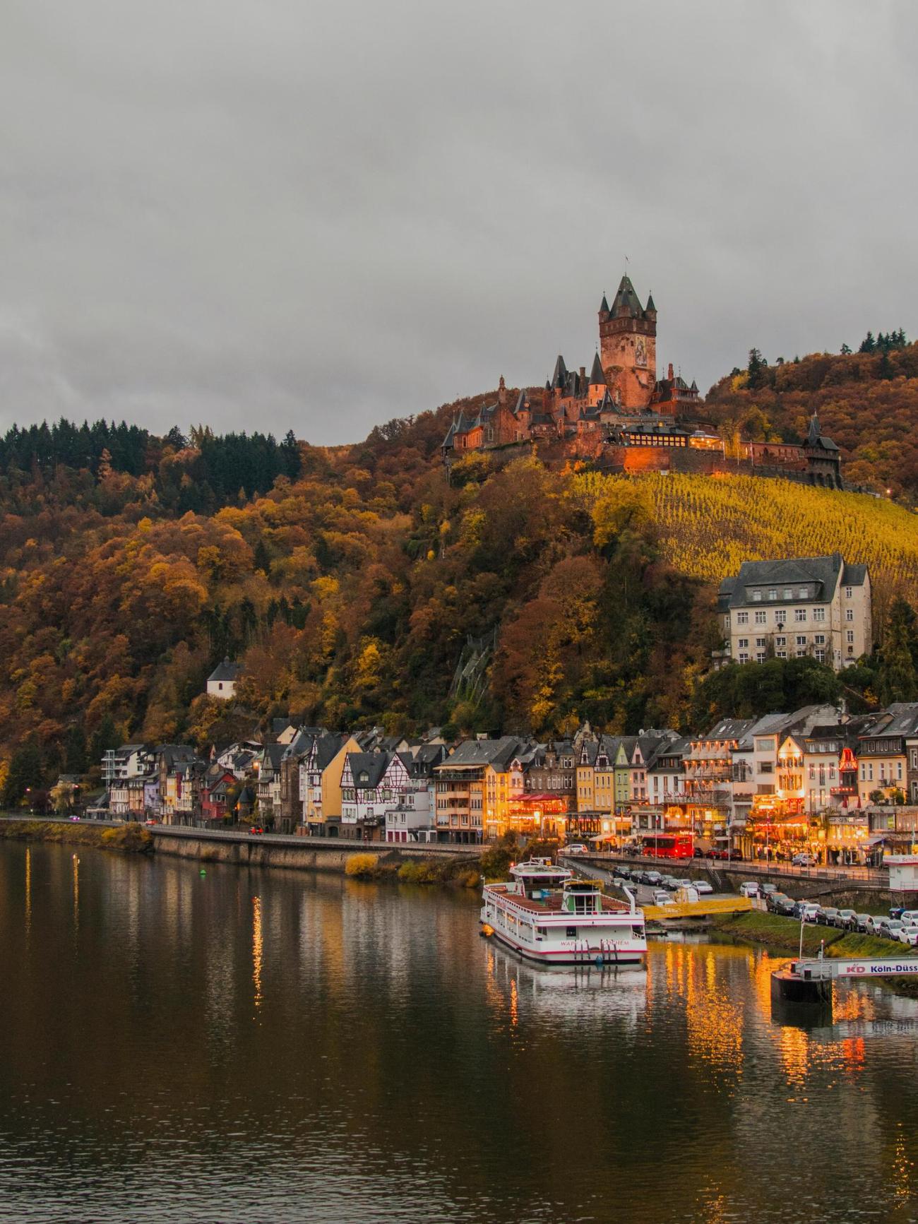 A riverside town below a hilltop castle on a European river