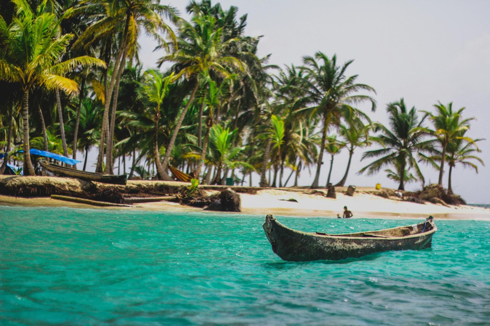 A small boat pulled up on a white sand beach in Belize