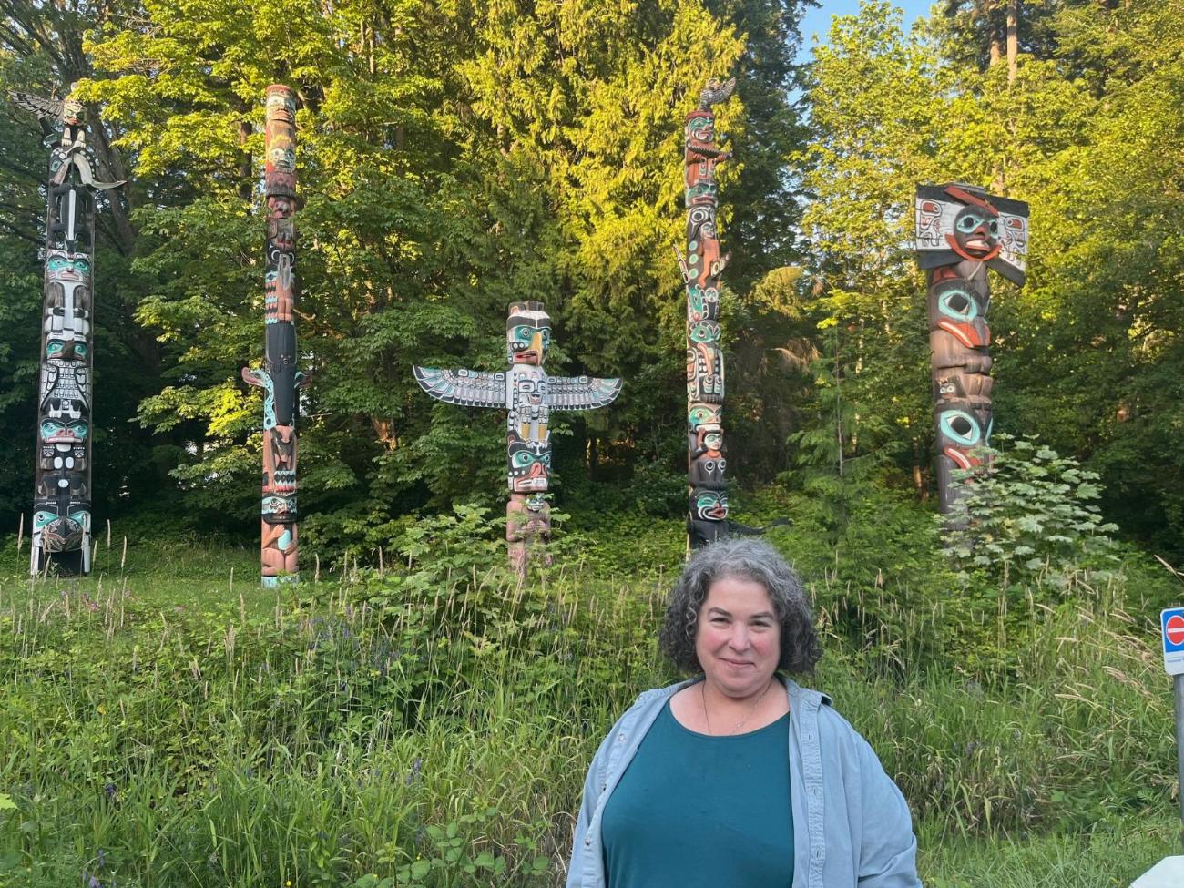 Rebecca Novick in front of the totem poles in Stanley Park, Vancouver