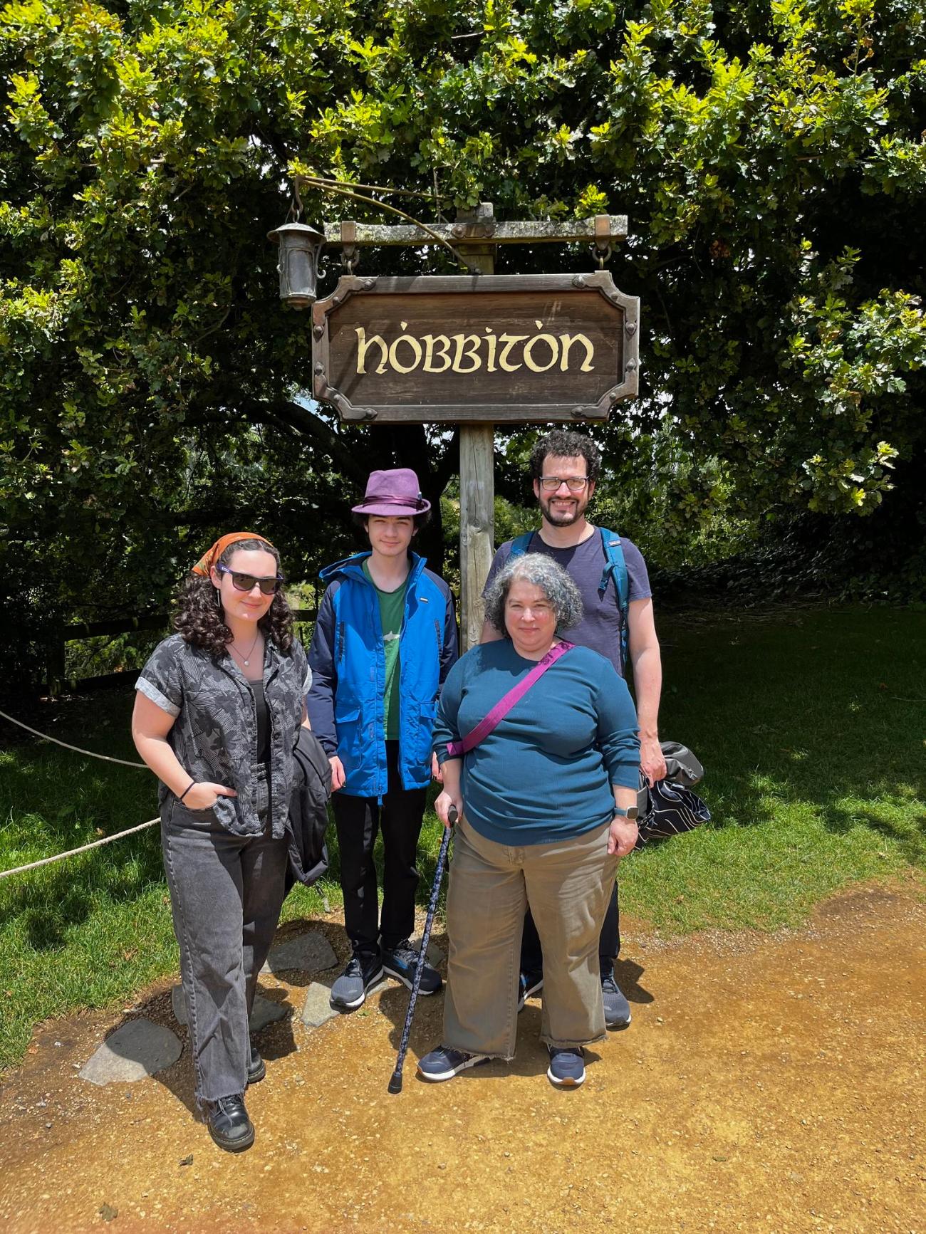 Rebecca and her family in front of the Hobbiton sign in New Zealand