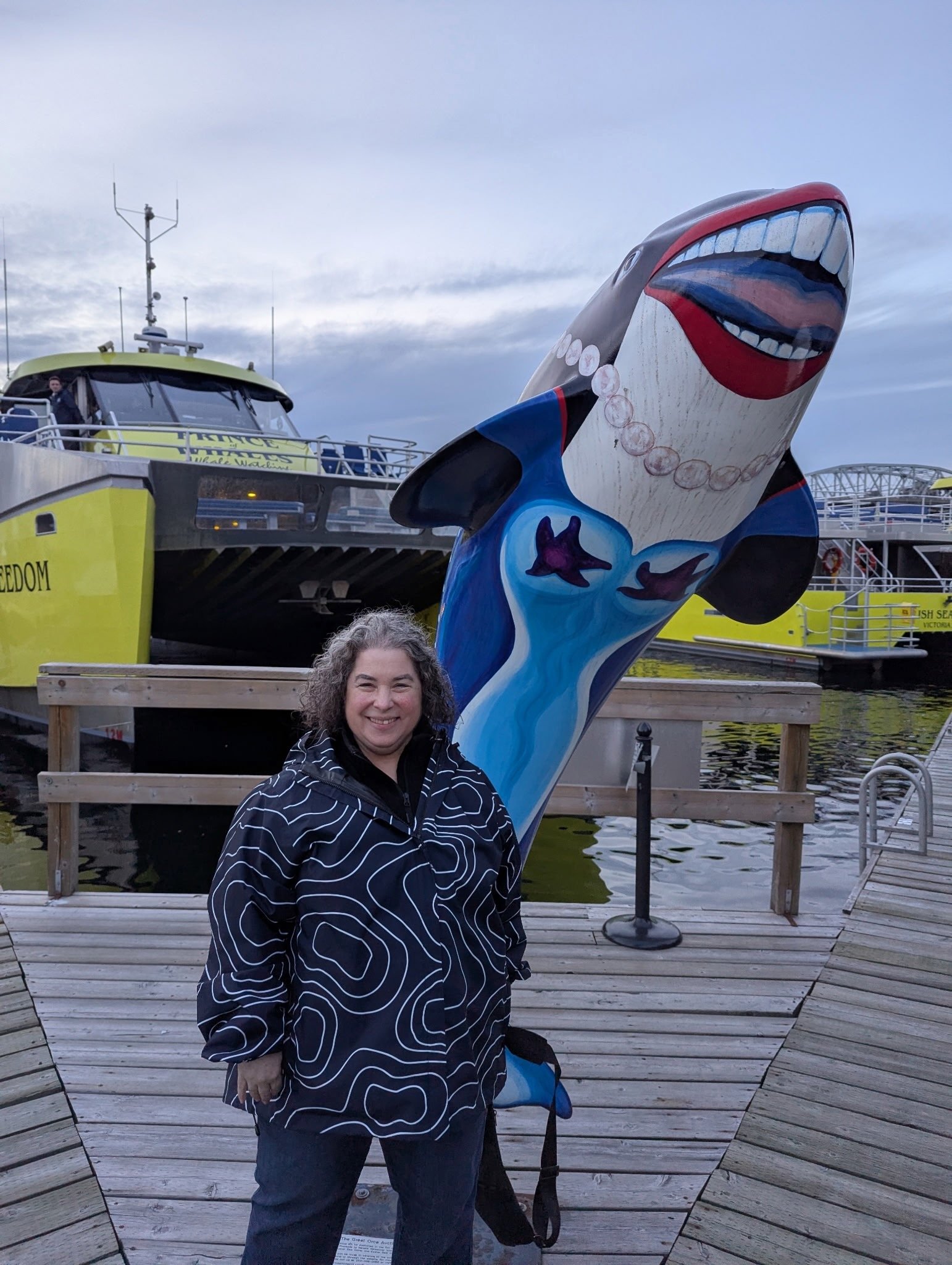 Rebecca Novick beside an orca sculpture in Vancouver